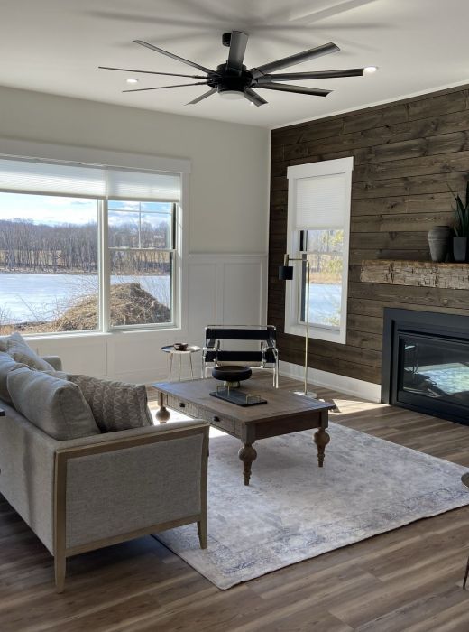 Mountain Crest Reserve rental home living room with large fireplace and sweeping view of lake and