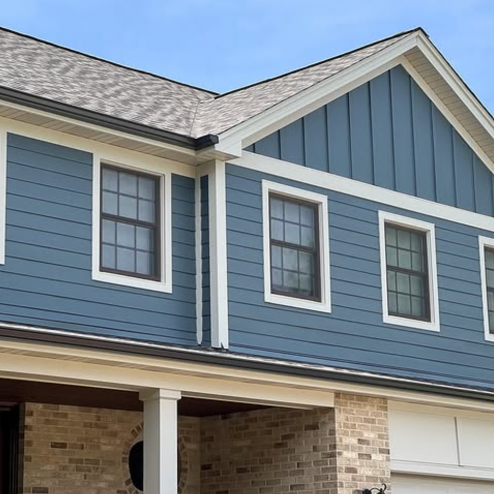 Blue two-story house at Mountain Crest Reserve with four windows and a brick lower exterior.