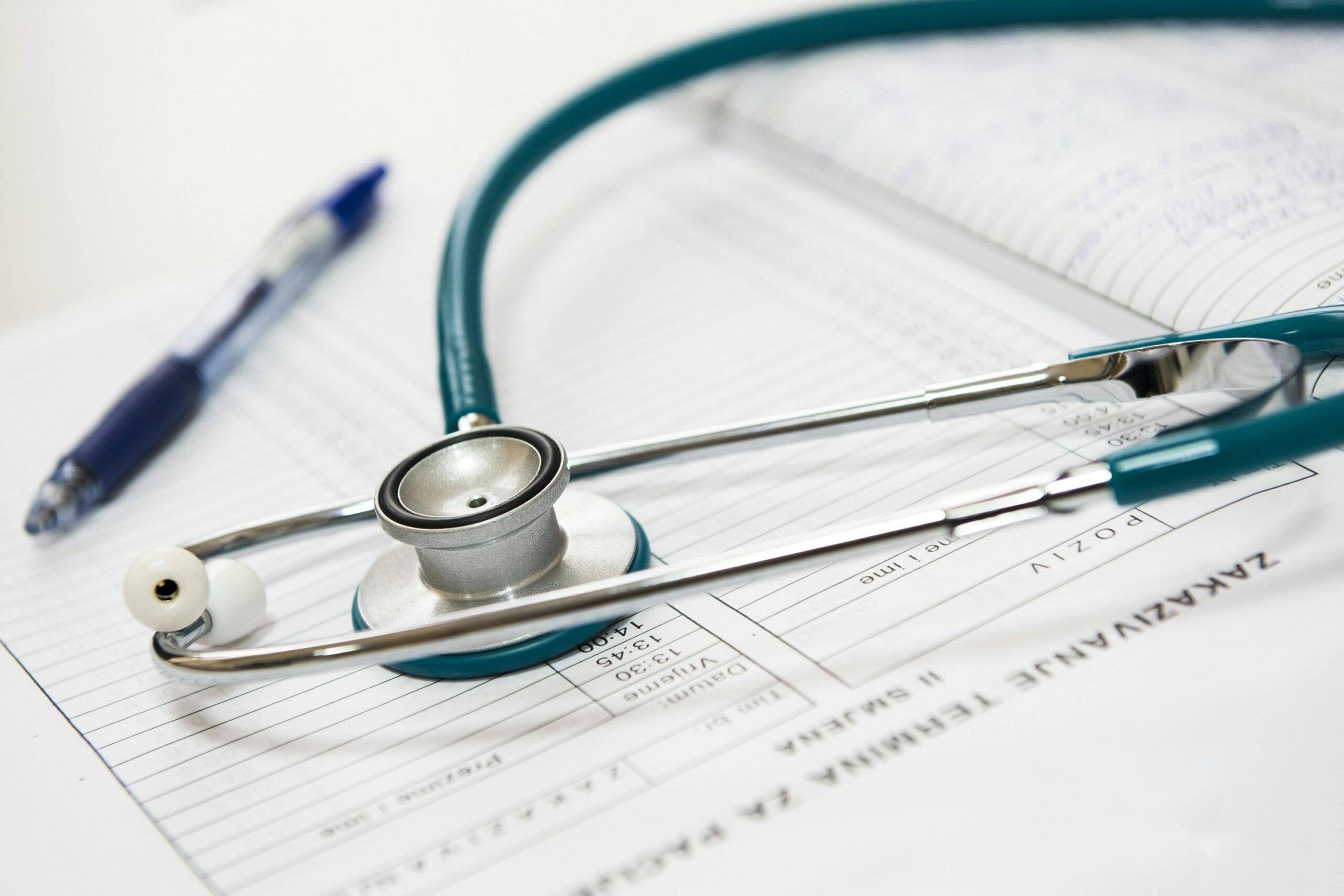 Stethoscope and pen on medical documents with charts and text.